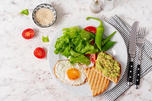 Fried egg fresh salad and avocado guacamole sandwiches Top view concept of a healthy lifestyle