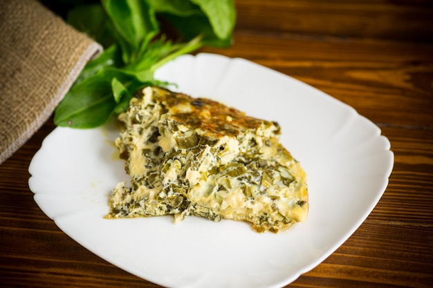 fried egg omelet with spring sorrel inside on a wooden table