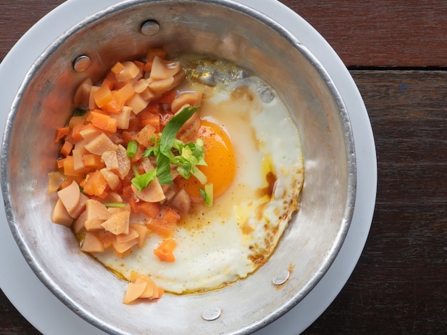 Fried Egg in Soy Sauce with Sausage and Carrots in pan