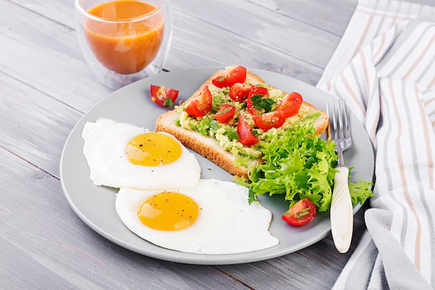 Fried egg, vegetable salad and grilled avocado sandwich