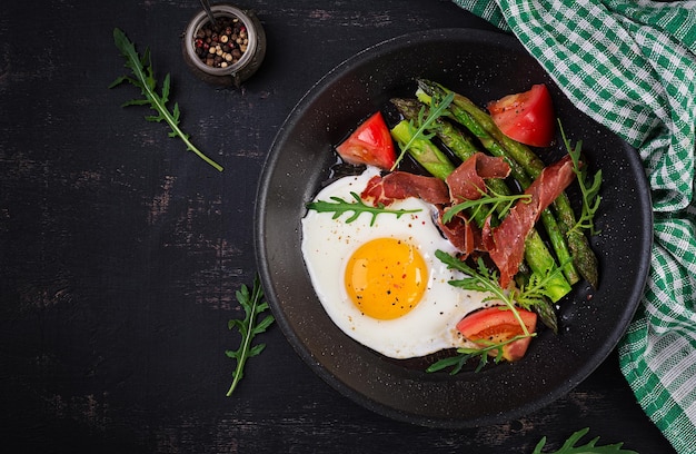 Fried egg with asparagus tomato and bacon Useful breakfast Top view overhead