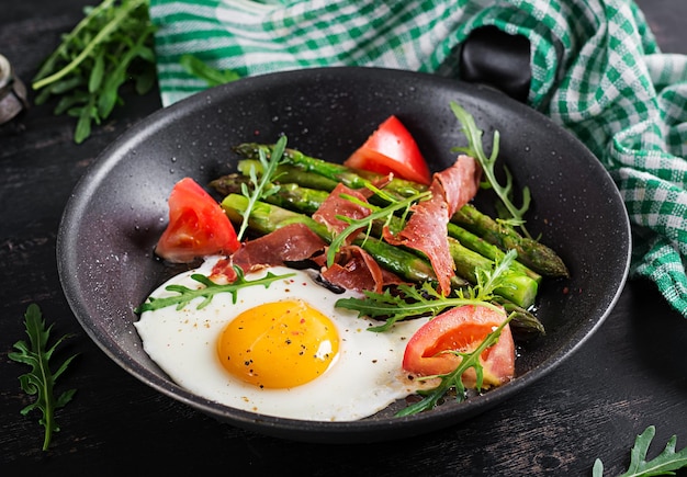 Fried egg with asparagus tomato and bacon Useful breakfast