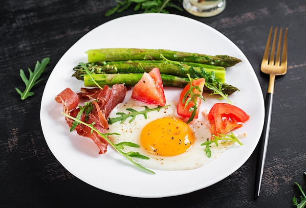 Fried egg with asparagus tomato and bacon Useful breakfast