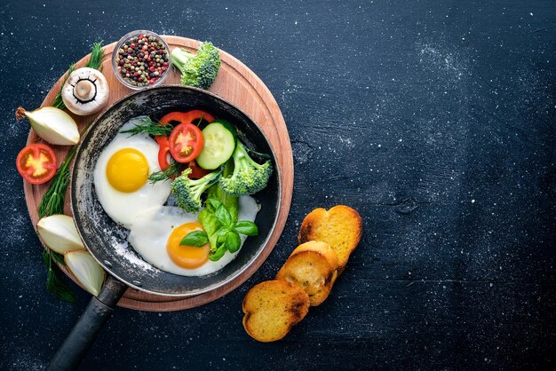 Fried egg with herbs toast bread and vegetables in a frying pan Top view Free space