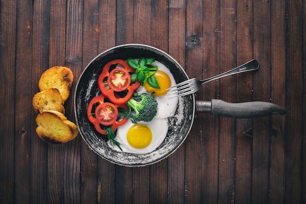 Photo fried egg with herbs toast bread and vegetables in a frying pan top view free space