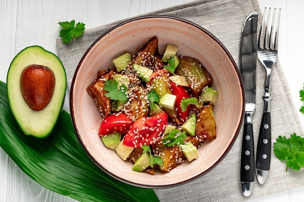 Fried eggplant with avocado tomatoes and sesame seeds Asian cuisine