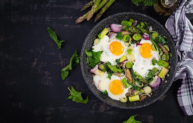 Fried eggs with asparagus leeks spinach and mushrooms Useful breakfast Top view overhead