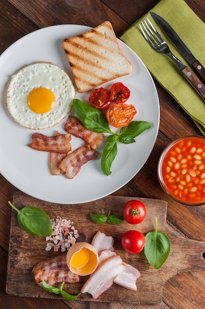 Fried eggs with bacon on breakfast on wooden rustic boards, food background