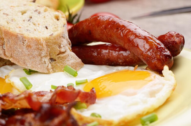 Fried eggs with bacon sausages and greens