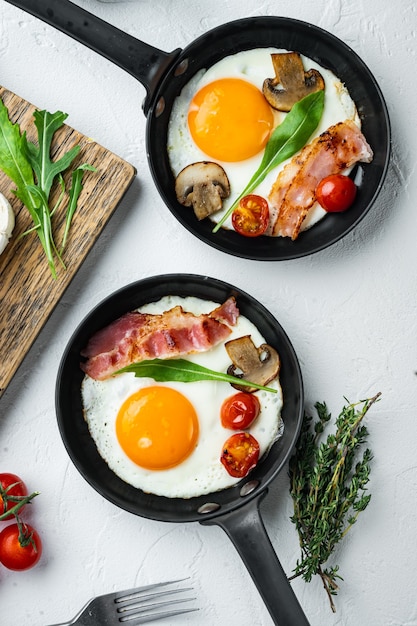 Fried eggs with bacon and vegetables set in pan