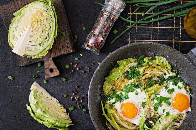 Fried eggs with slices of young cabbage and greens.