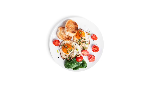 Fried eggs with vegetables and toasts on white plate isolated on a white background. Beautiful breakfast. High quality photo