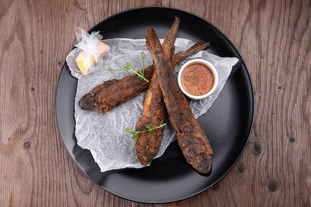 Fried fish on a black plate, Gobies