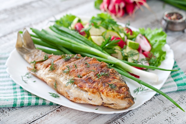 Fried fish carp and fresh vegetable salad