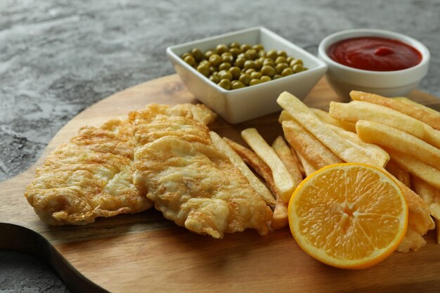 fried fish and chips on gray textured background