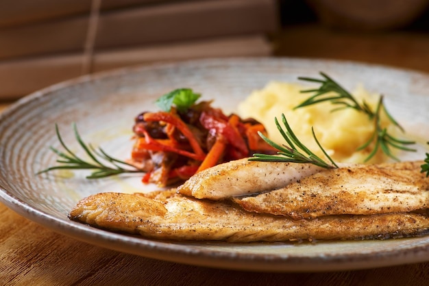 Fried fish with mashed potatoes and vegetable