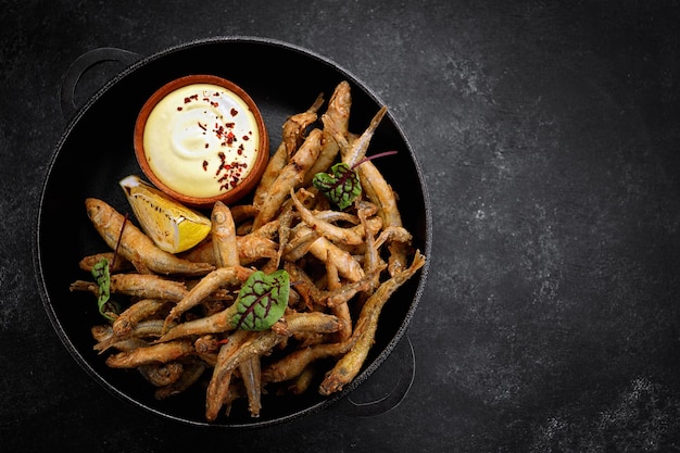 Fried fish with sauce appetizer on gray concrete