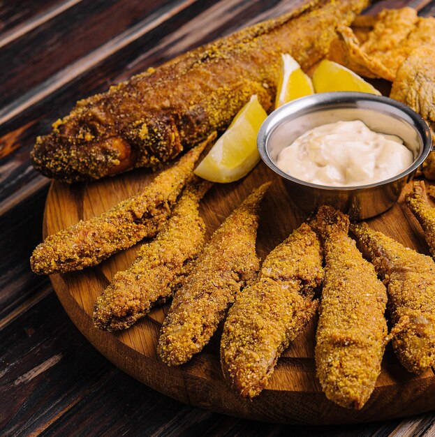 Fried fishes set on wooden board