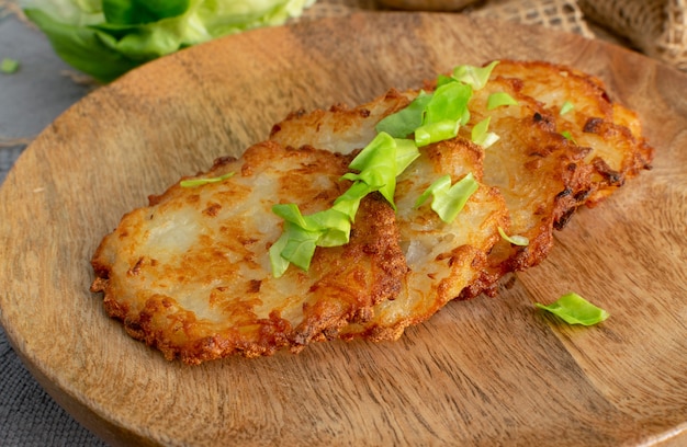 Fried grated vegetable pancakes or potato fritter on rustic background