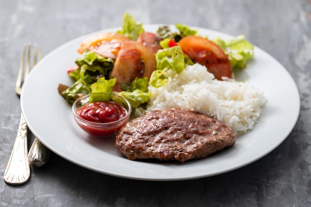 Fried ground meat with tomato sauce and boiled rice on dish