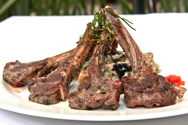 Fried lamb meat chops with risotto rice on restaurant table food gastronomy