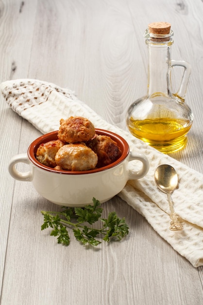 Fried meat cutlets in ceramic soup bowl branch of fresh parsley