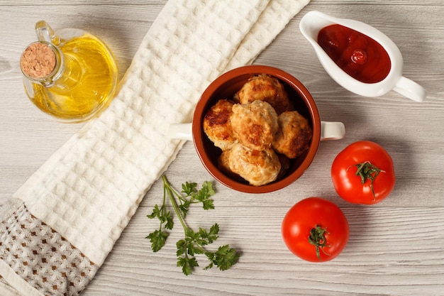 Fried meat cutlets in ceramic soup bowl tomatoes and ceramic sauce boat