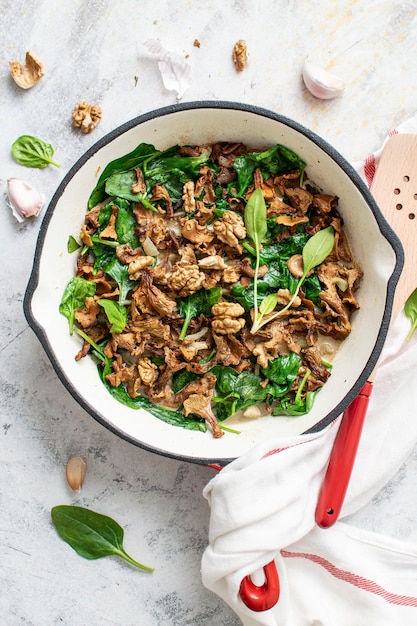 Fried mushrooms and spinach in a pan