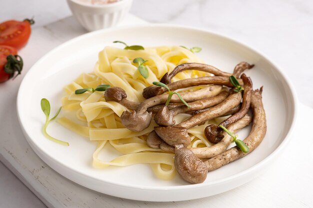 Fried mushrooms with pasta shimeji and noodles on plate on white background