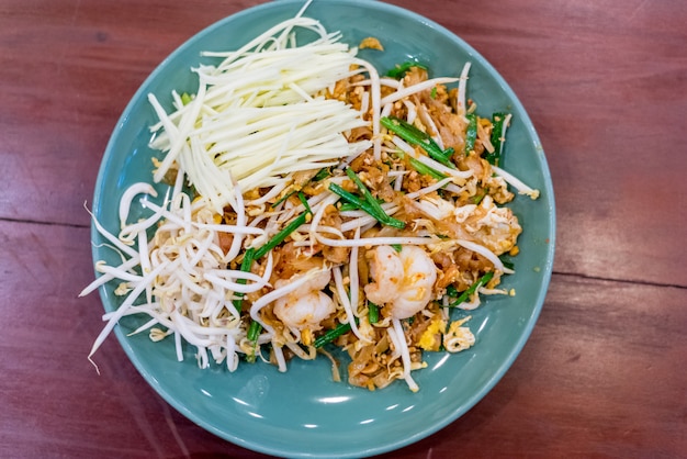 Fried noodle Thai style with prawns "Pad Thai"
on a wooden table