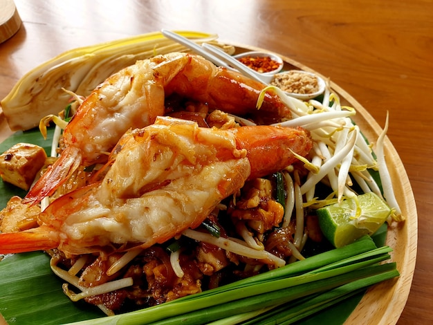 Fried noodle Thai style with river prawns on wooden plate