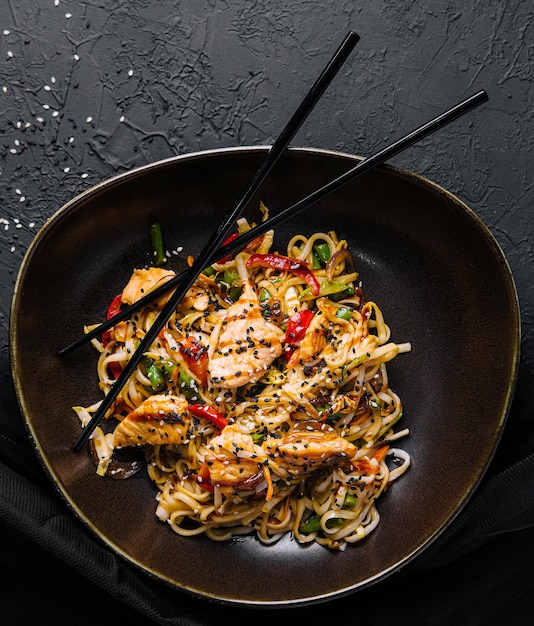 Fried noodles with chicken on top view