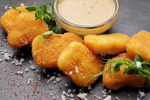 fried nuggets with chicken sauce on a dark background