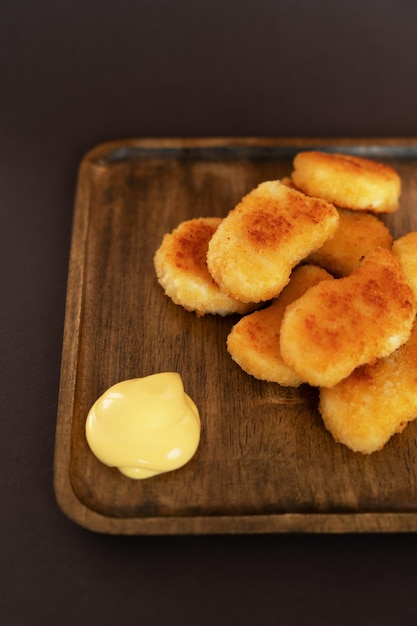 Fried nuggets on a wooden plate