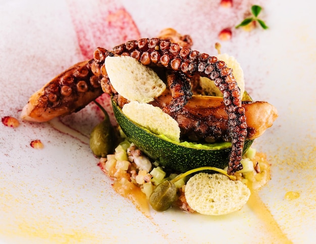 Fried octopus with avocado on plate