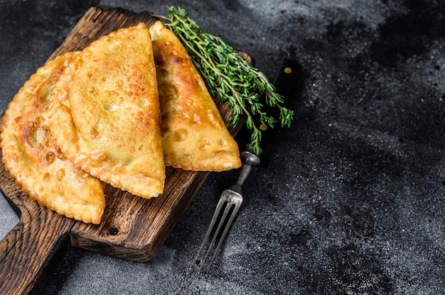 Fried in oil chebureks with meat and herbs, traditional Caucasian cuisine