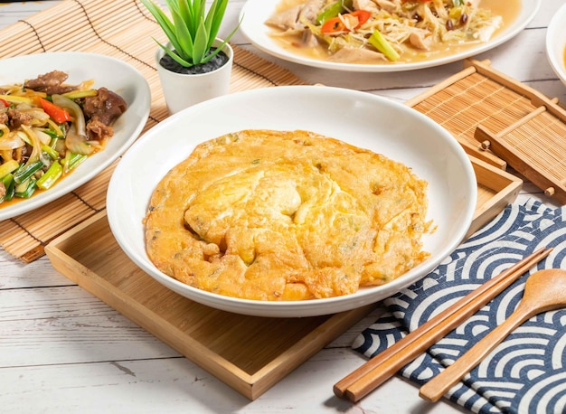 Fried Onion Egg served in a dish isolated on wooden tray and napkin side view of taiwan food