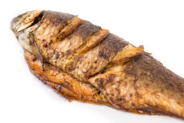 Fried or oven baked whole fish isolated on white background