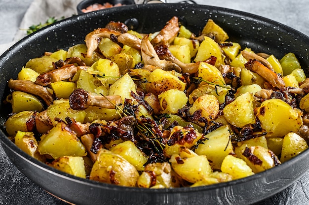 Fried oyster mushrooms with potatoes in a pan. Top view