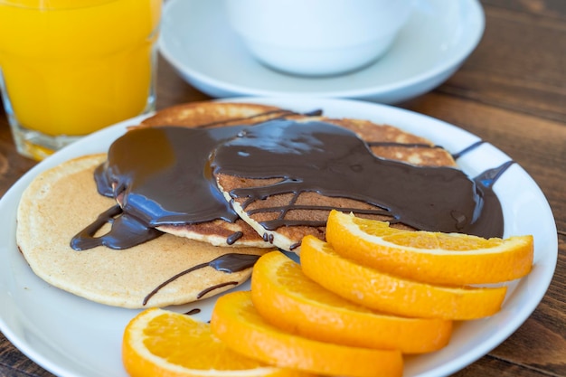 Fried pancakes oranges coffee juice on wooden table Breakfast concept Close up