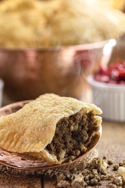 Fried pastry filled with ground meat and potatoes, hot sauce served hot.