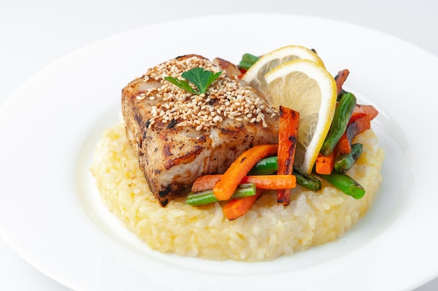 Fried perch fillet with rice and vegetables On a white plate On a white background Isolated Closeup