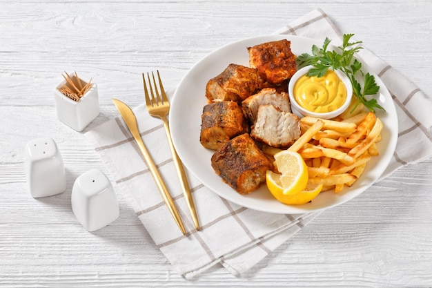 Fried pieces of hake on a plate with french fries