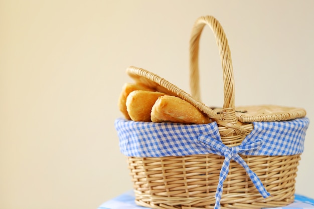 Fried pies in a wicker basket On a blue striped napkin on beige