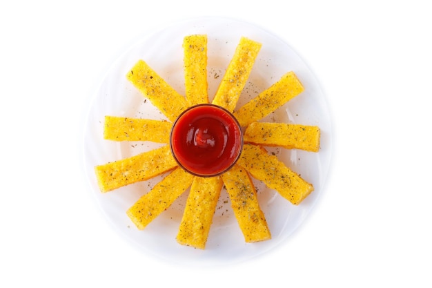 Fried polenta with ketchup on dish isolated on white background