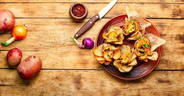 Fried potato with bacon on plate over wooden table