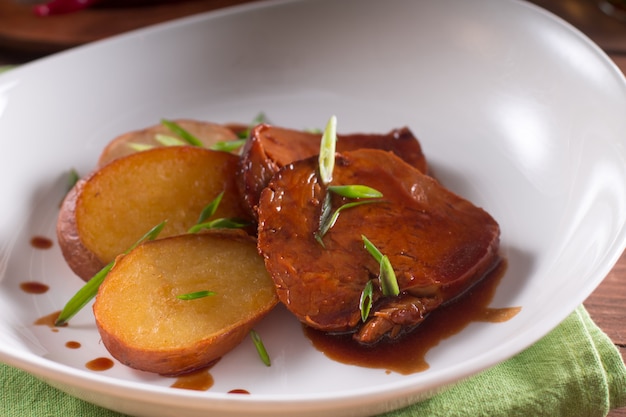 Fried potatoes and meat slices in sauce, simple country dish