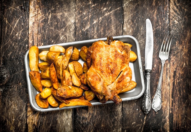 Fried potatoes with chicken on a tray.