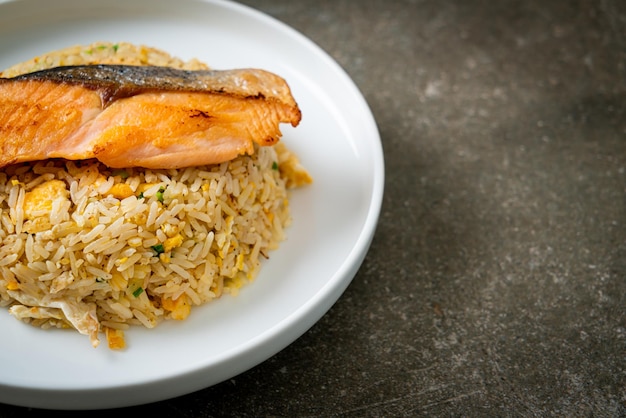 fried rice with grilled salmon fillet steak on white plate