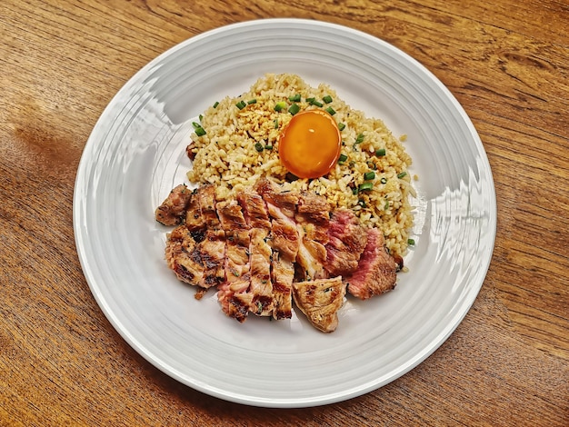 Fried Rice with Medium Rare Beef Steak and Egg on Wooden Table